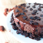 double dark chocolate ganache cheesecake with brownie crust on a white plate